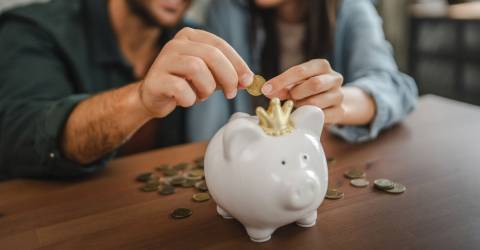 Volwassen stel spaart thuis geld in een spaarpot